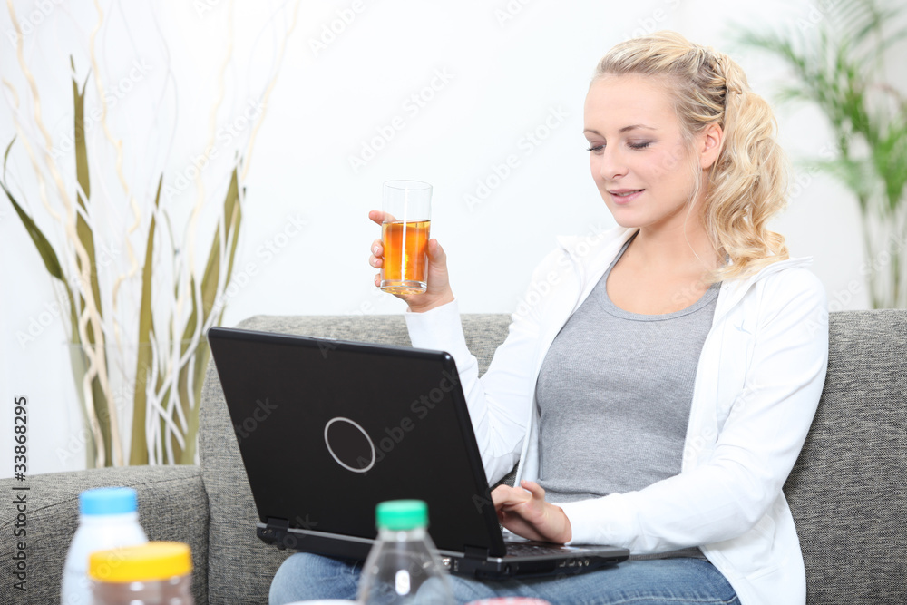 Woman surfing the internet and drinking a glass of apple juice Woman surfing the internet and drinking a glass of apple juice