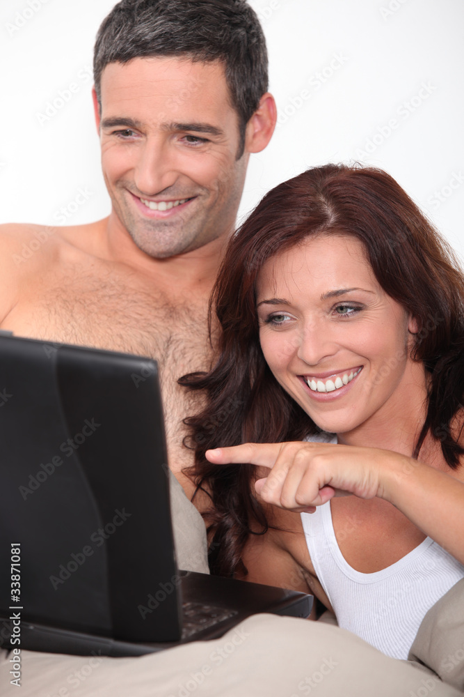 a couple laughing behind a computer