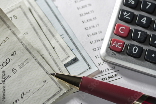 Checks, calculator, statement and pen