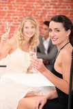 Two female friends drinking champagne in restaurant
