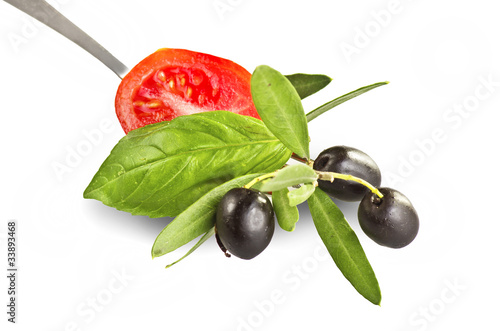 Olives tomato and basil on fork