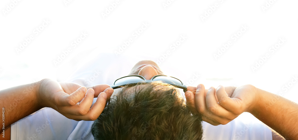 Naklejka premium Beautiful brunette men at the beach in sunrise time.