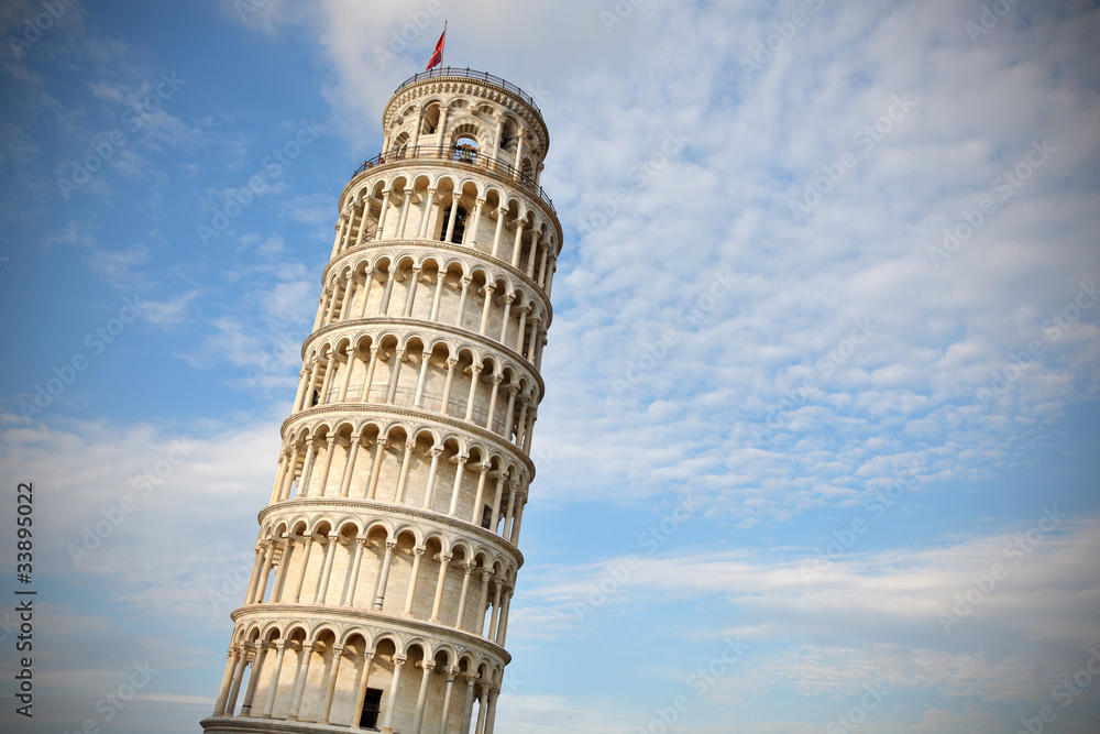 Leaning tower of Pisa at sunset, with cloudy blue skies