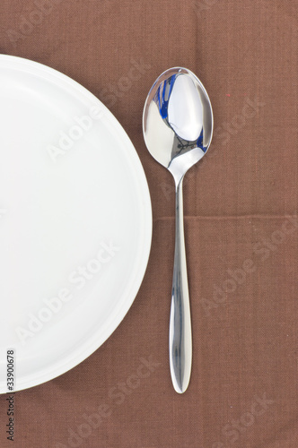 Spoon and dish on a napkin as a dining room serving.