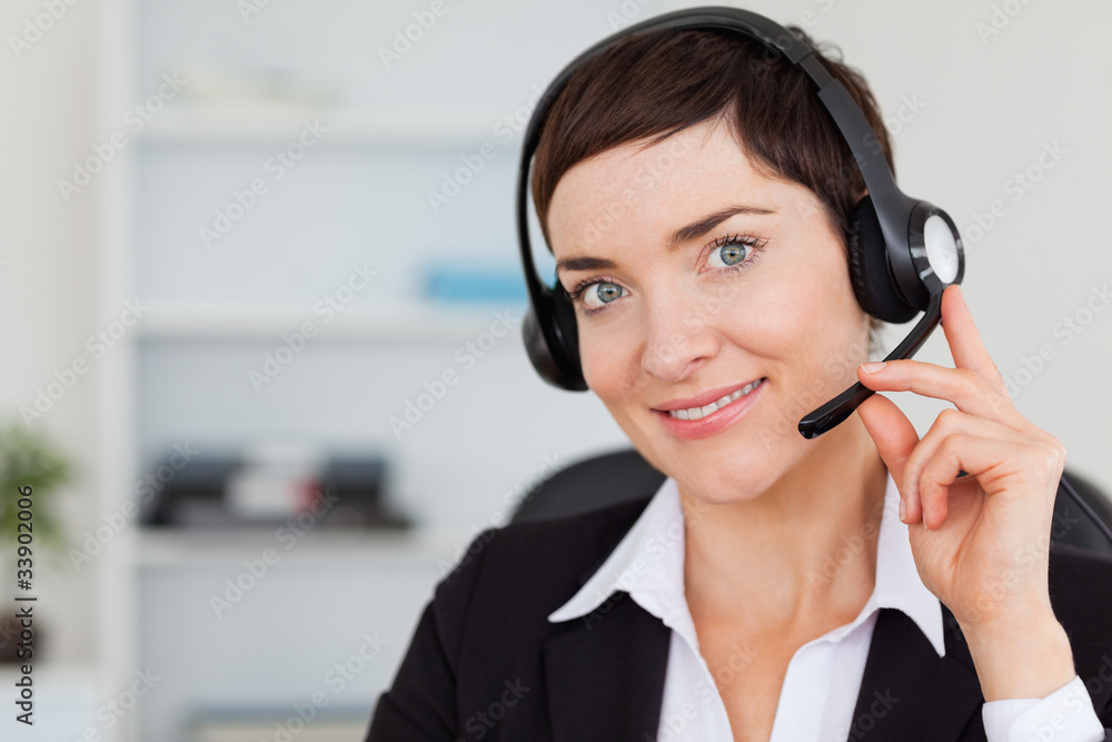 Close up of a smiling secretary calling with a headset Close up of a smiling secretary calling with a headset