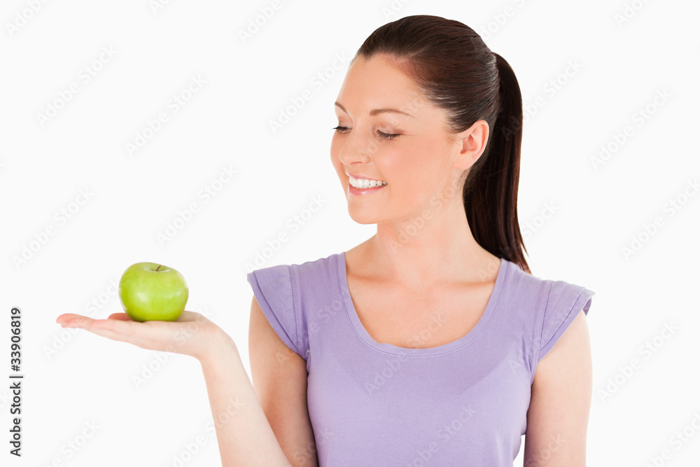 Good looking woman holding an apple while standing Good looking woman holding an apple while standing