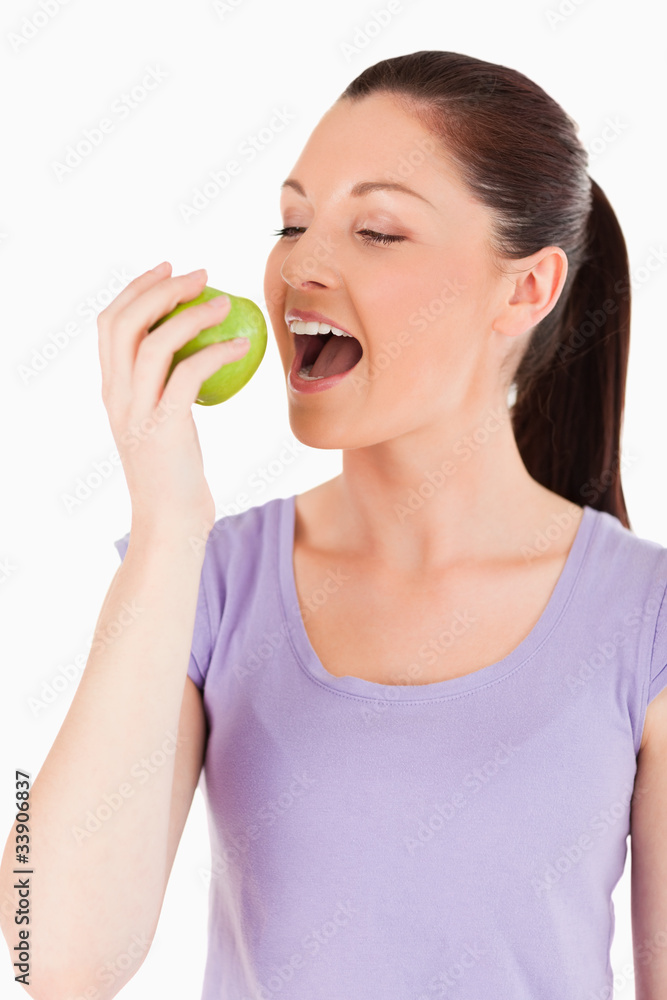 Beautiful woman eating an apple while standing Beautiful woman eating an apple while standing