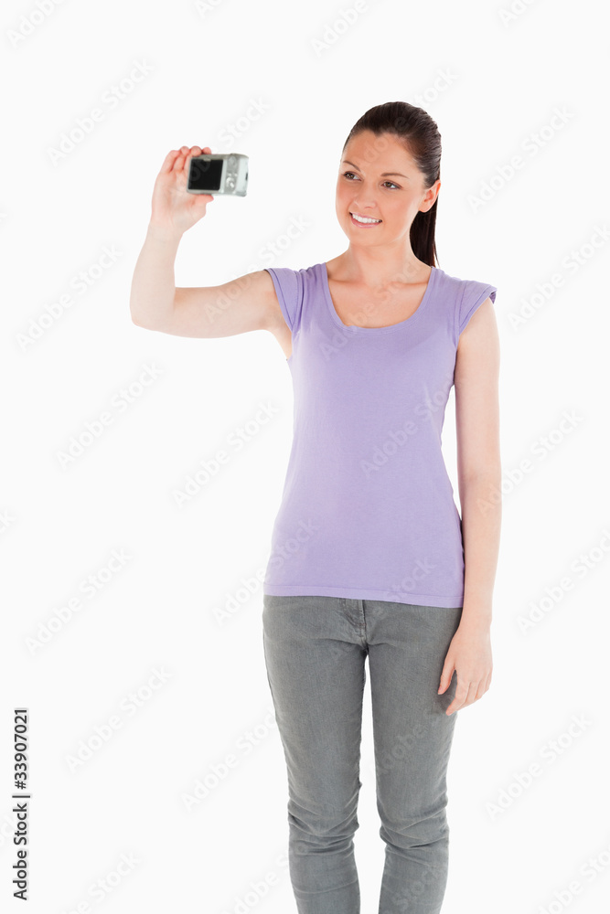 Beautiful woman using a camera while standing Beautiful woman using a camera while standing