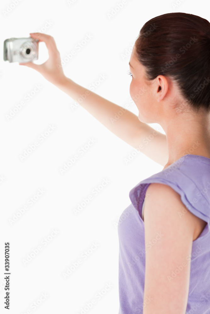 Charming woman using a camera while standing Charming woman using a camera while standing