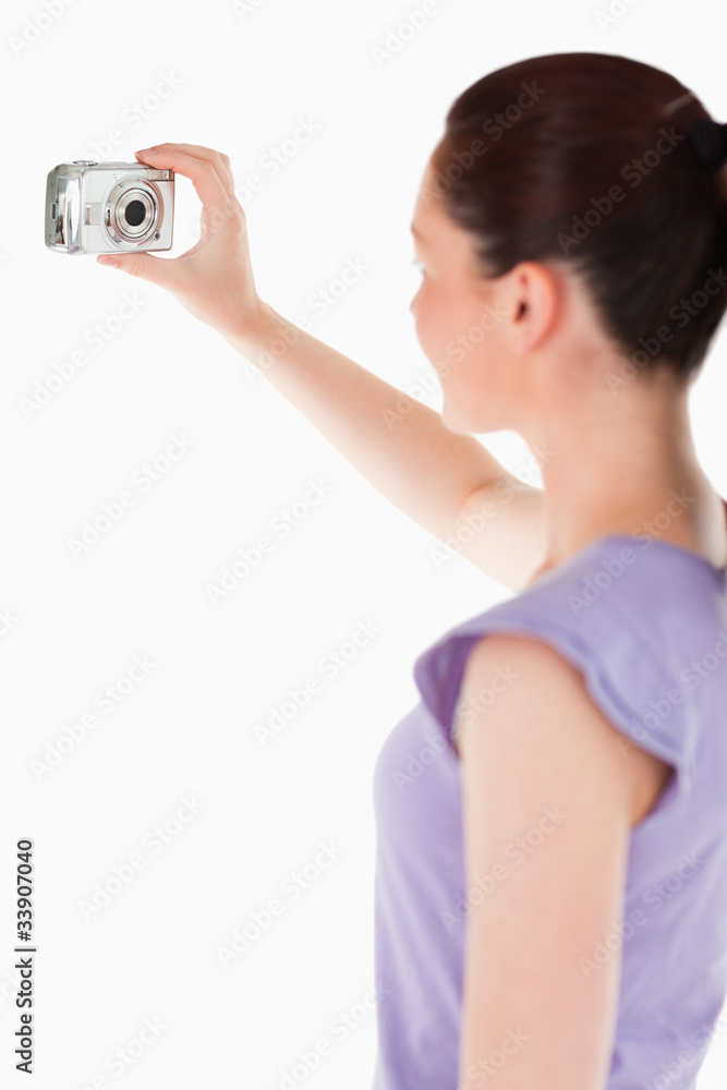 Lovely woman using a camera while standing Lovely woman using a camera while standing