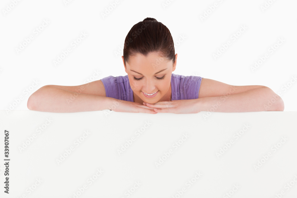 Beautiful woman posing behind a billboard while standing Beautiful woman posing behind a billboard while standing