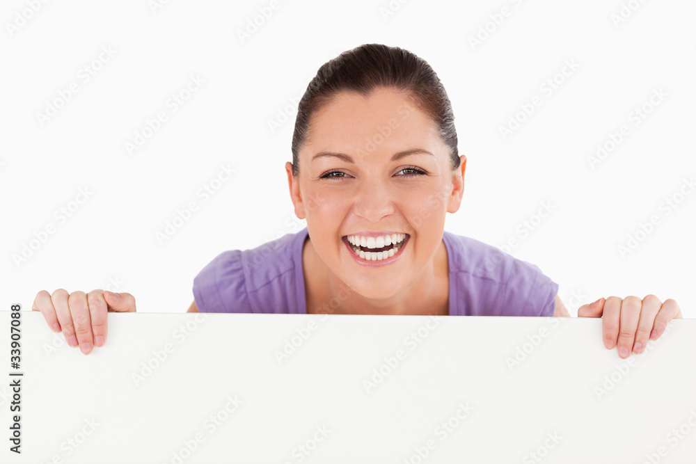 Portrait of a good looking woman posing behind a billboard while Portrait of a good looking woman posing behind a billboard while