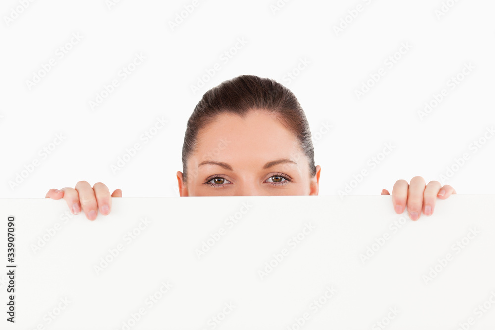 Portrait of a beautiful woman posing behind a billboard while st Portrait of a beautiful woman posing behind a billboard while st