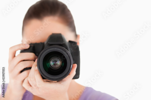Good looking female using a camera while standing