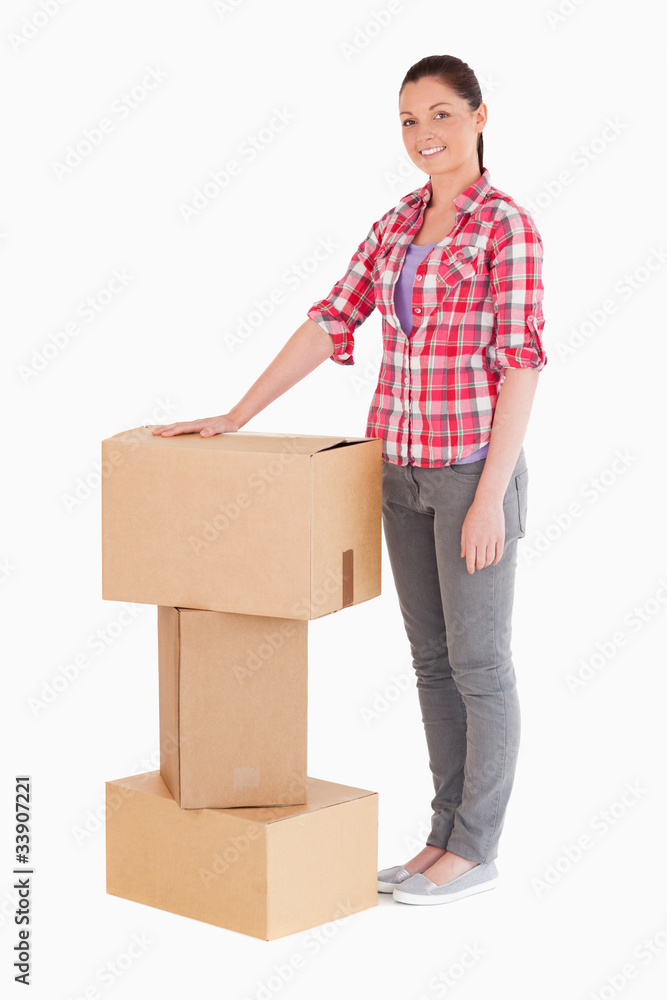 Beautiful woman posing with cardboard boxes while standing Beautiful woman posing with cardboard boxes while standing