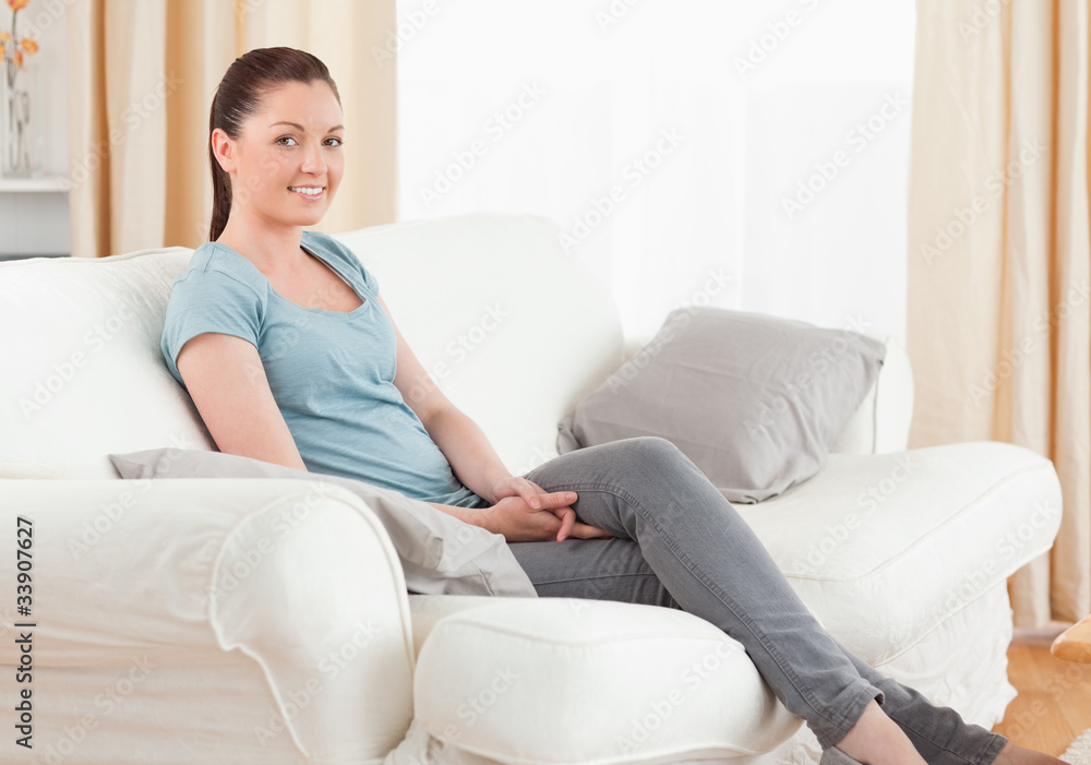 Fototapeta premium Beautiful woman posing while sitting on a sofa