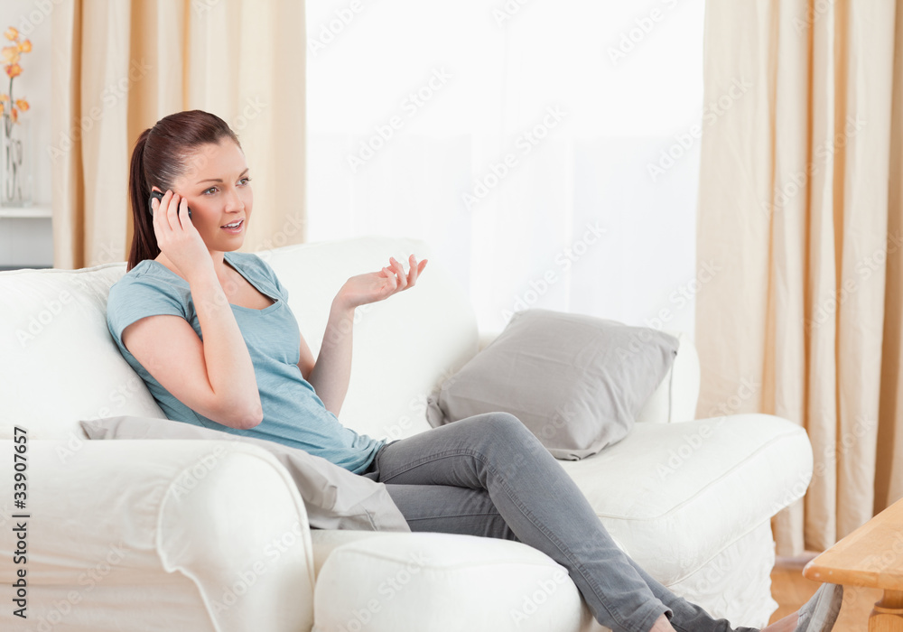 Upset woman on the phone while sitting on a sofa Upset woman on the phone while sitting on a sofa