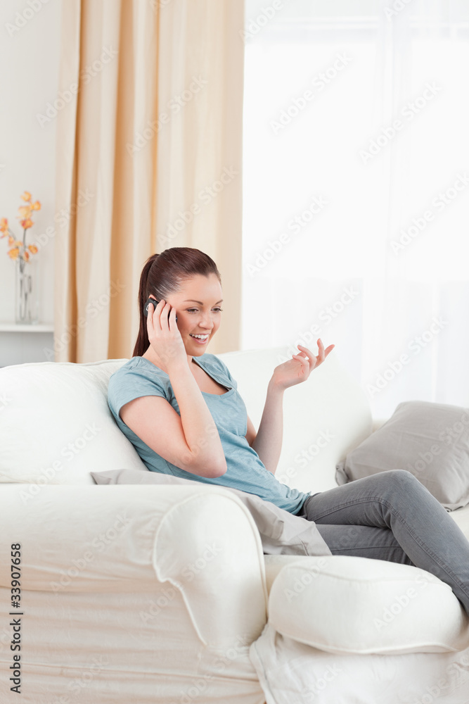 Gorgeous woman on the phone while sitting on a sofa Gorgeous woman on the phone while sitting on a sofa