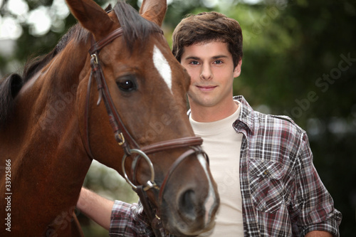 young man and a horse in the forest photo