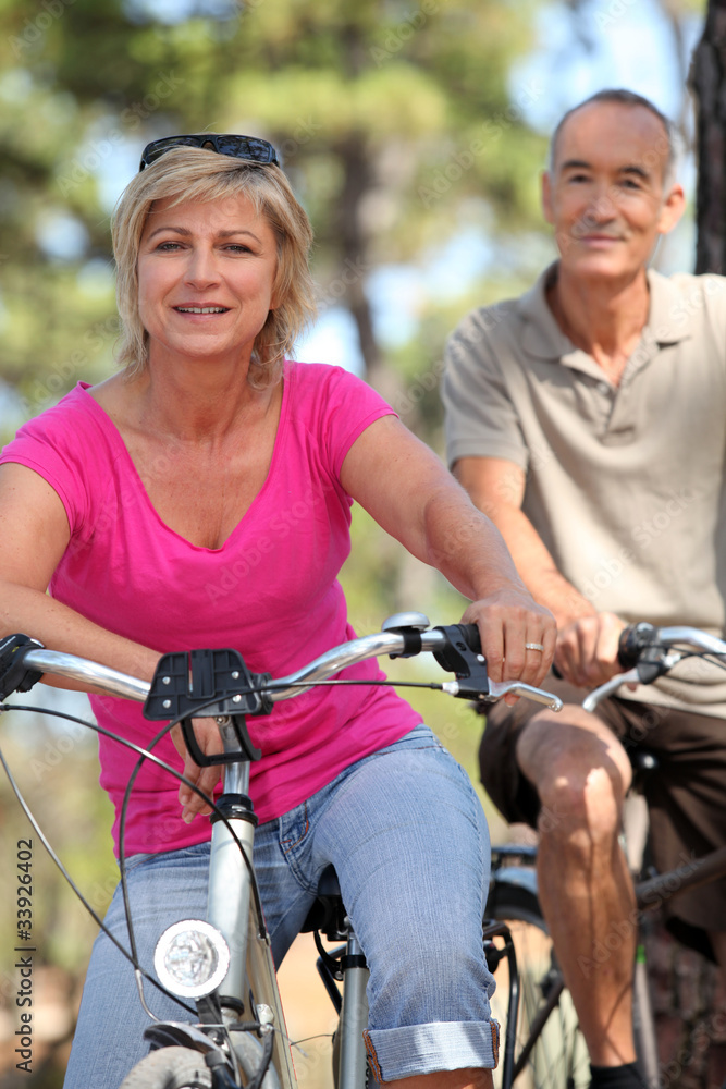 Obraz premium 60 years old man and woman doing bike