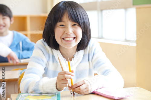 席に座って微笑む小学生女子