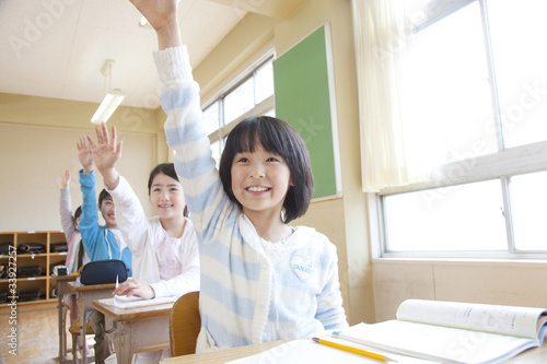 授業中に手を挙げる小学生男女