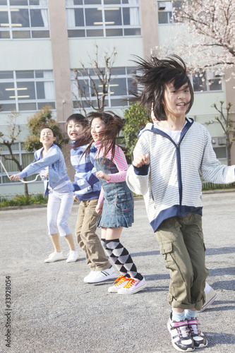 大縄跳びをする小学生4人と教師