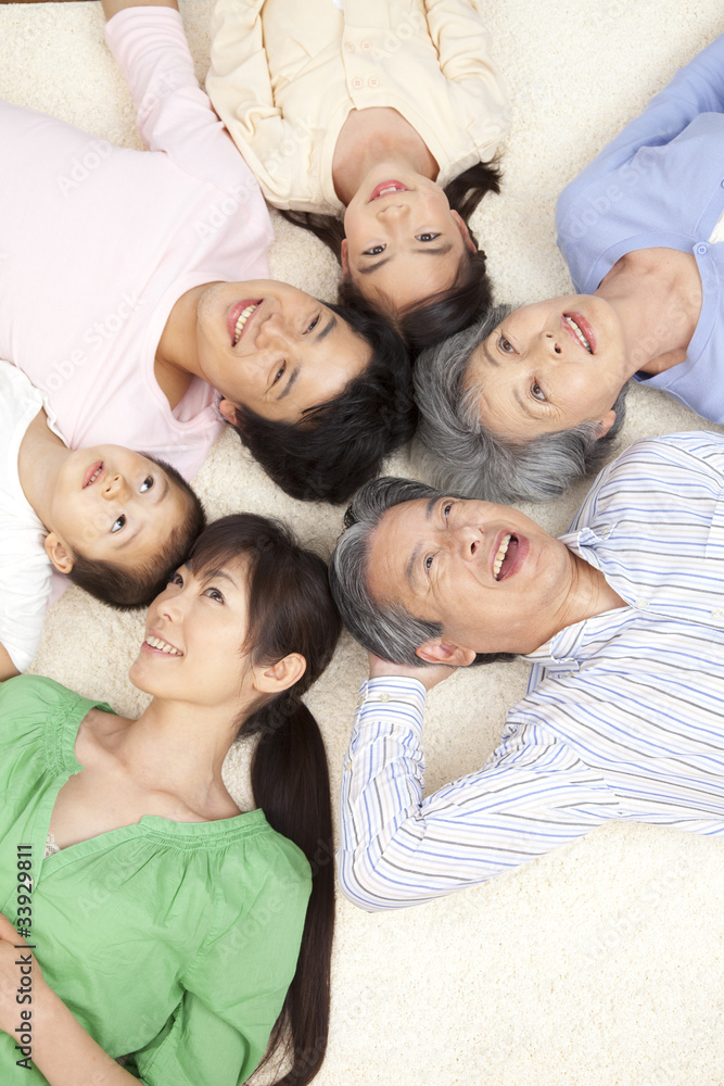 寝転がって微笑む親子3世代