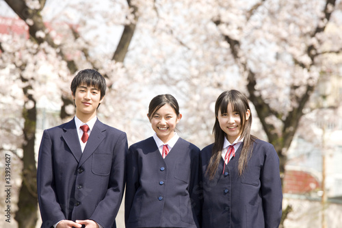 桜の下で笑っている中学生男女