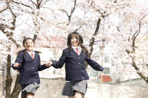 手を繋いで走る2人の女子中学生 © paylessimages