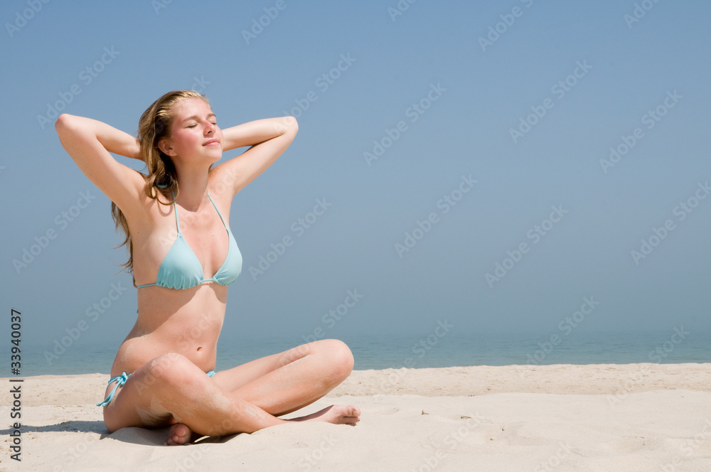 Beautiful girl in bikini on the beach - space for text