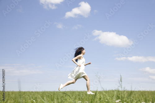 草原を走る女性
