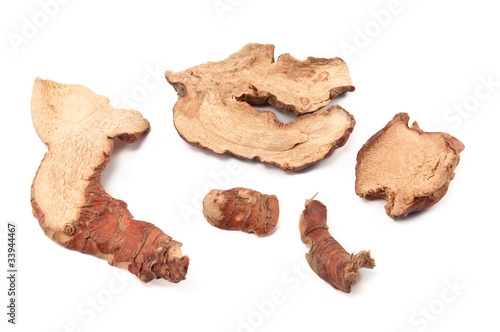 Dried slices of galangal on white background