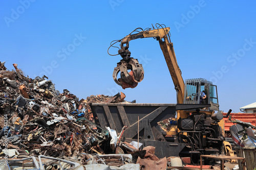 Recycling industry, crane, press and heap of metal