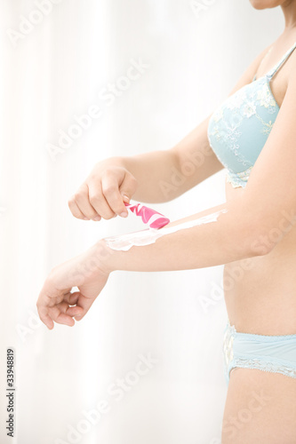 腕の無駄毛を処理する女性