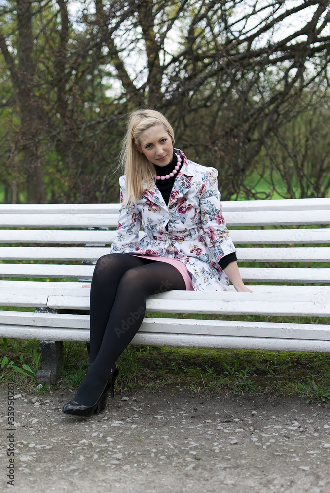 blonde girl sitting on a park bench blonde girl sitting on a park bench