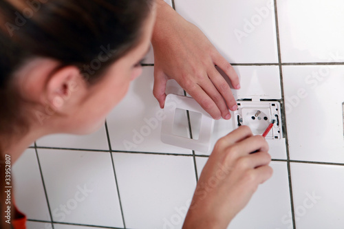 Woman fixing an outlet