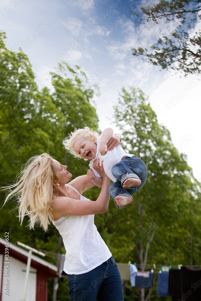 Obraz premium Mother Throwing Son in Air