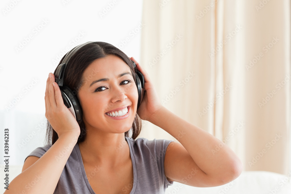 close up of a charming woman with earphones looking into camera close up of a charming woman with earphones looking into camera