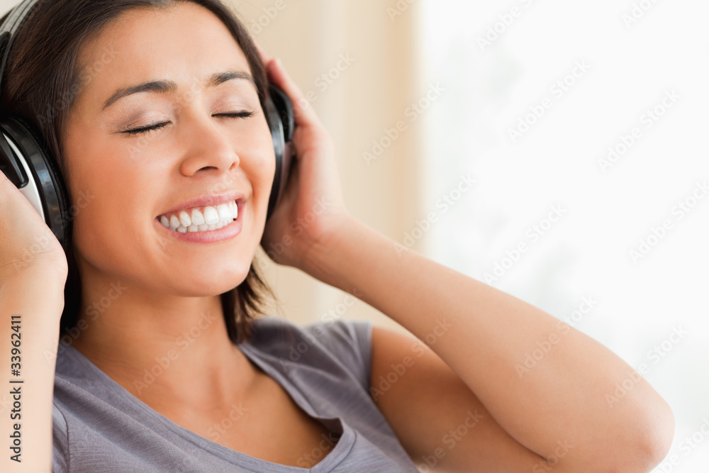 close up of smiling woman sitting on sofa with earphones and eye close up of smiling woman sitting on sofa with earphones and eye