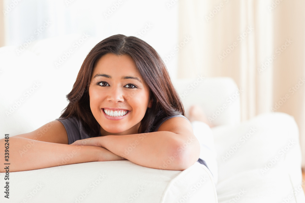 woman lying on sofa with crossed arms looking into camera woman lying on sofa with crossed arms looking into camera