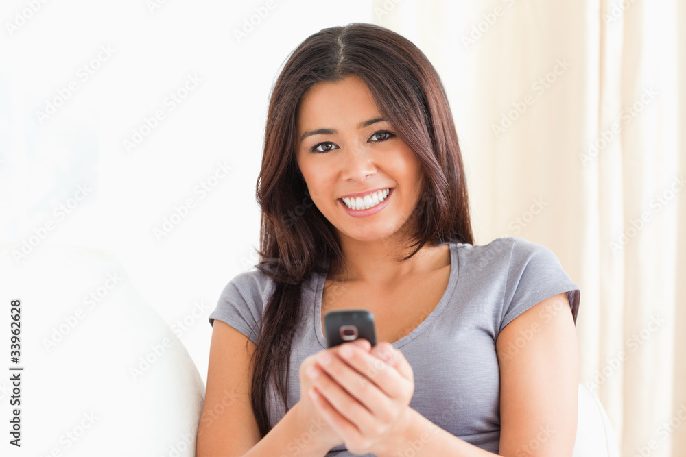 close up of a cheerful woman with mobile phone looking into came close up of a cheerful woman with mobile phone looking into came