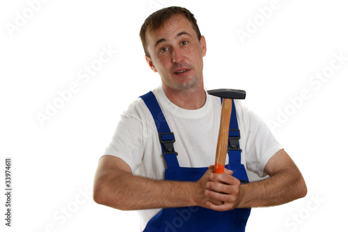 Handwerker mit blauer Latzhose hält einen Hammer