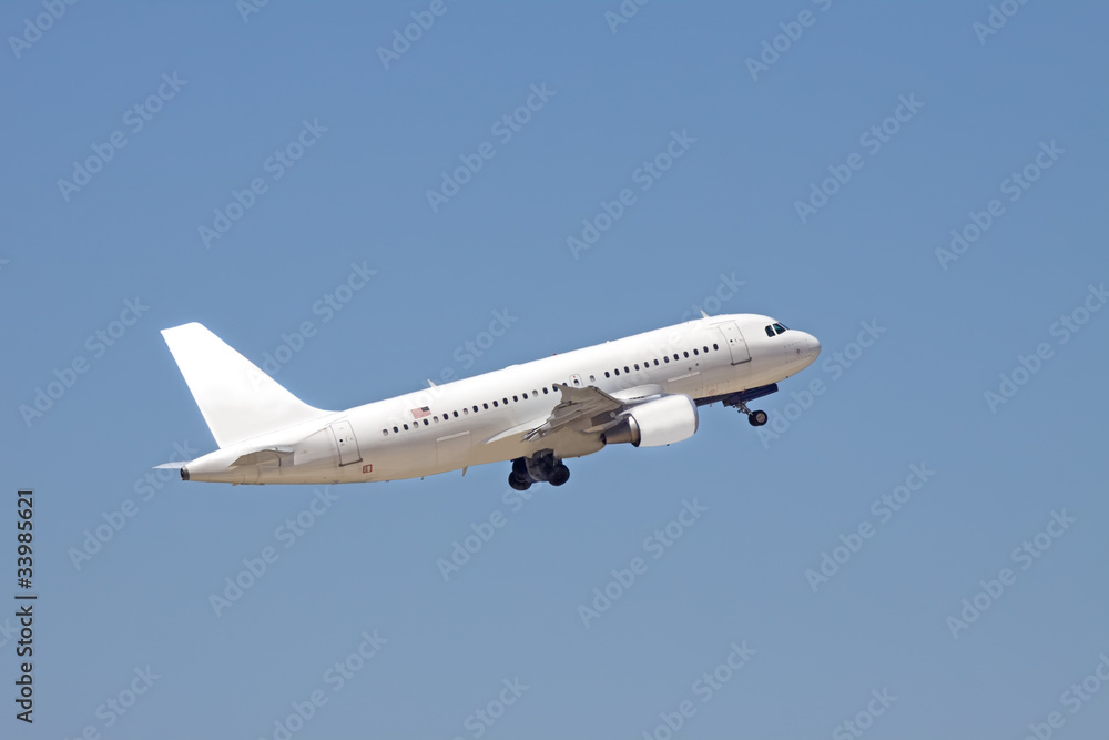 A white passenger plane flies into a blue sky. A white passenger plane flies into a blue sky.
