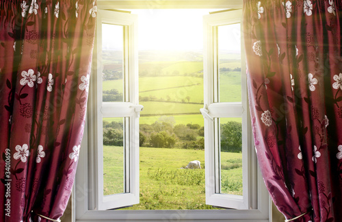 Obraz Otwarte okno z widokiem na okolicę i wpadającym światłem słonecznym
