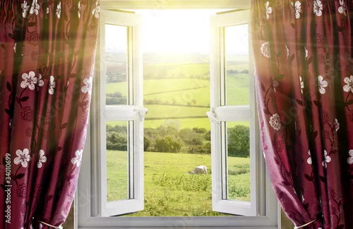 Fototapeta Otwarte okno z widokiem na okolicę i wpadającym światłem słonecznym