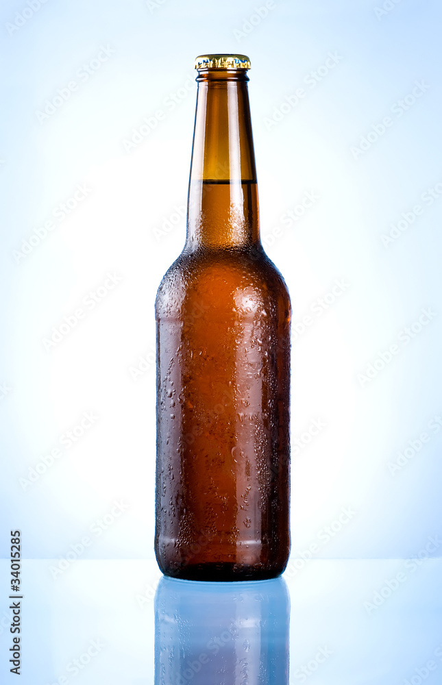 Full brown bottle with condensation on a blue background