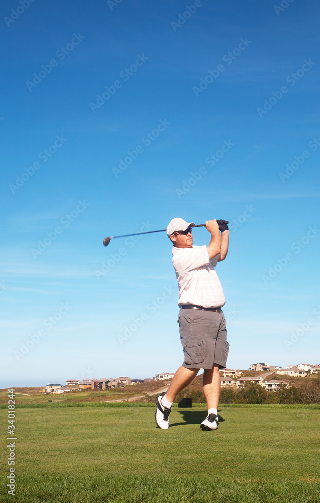 Fototapeta premium Young male golfer playing off the tee box