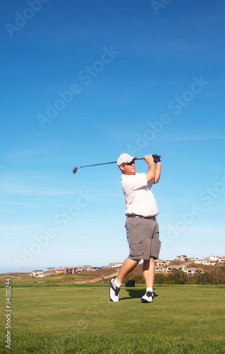 Young male golfer playing off the tee box
