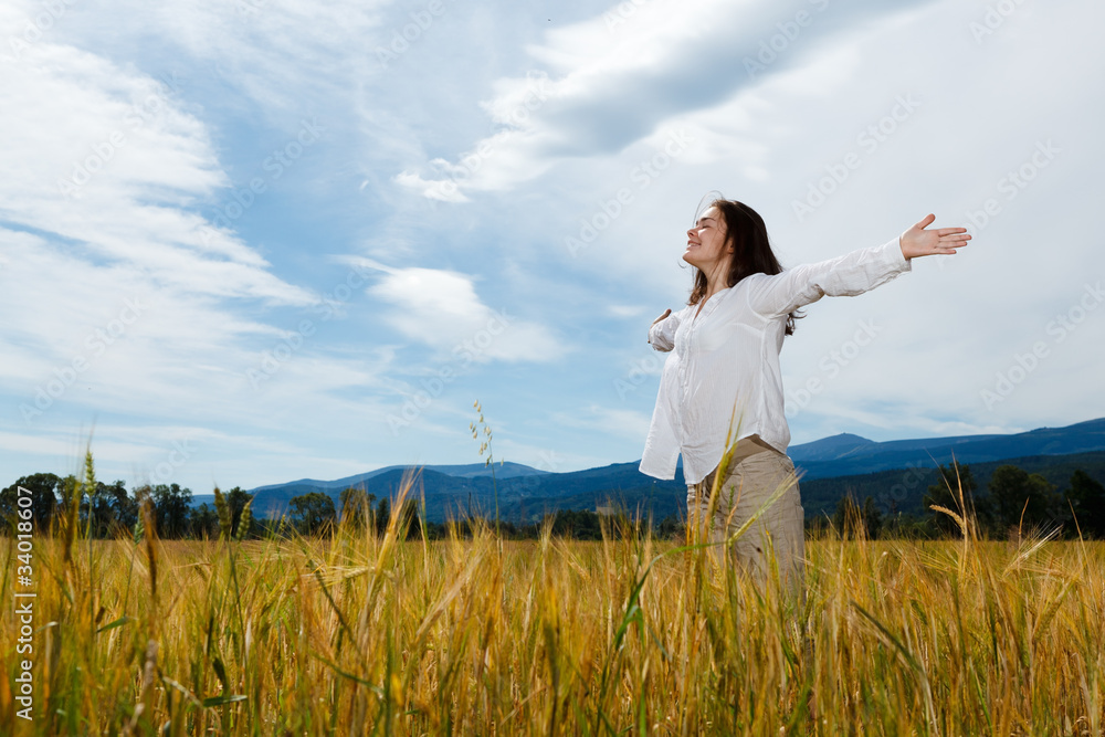 Girl holding arms up against blue sky